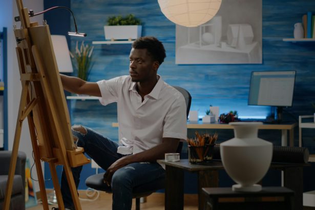 African american creative man using vase for drawing inspiration