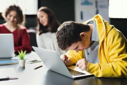 Down-syndrome man with laptop attending education, inclusivity of disabled person.