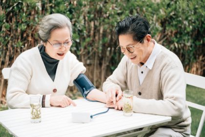 Senior couple checking their blood pressure in the yard